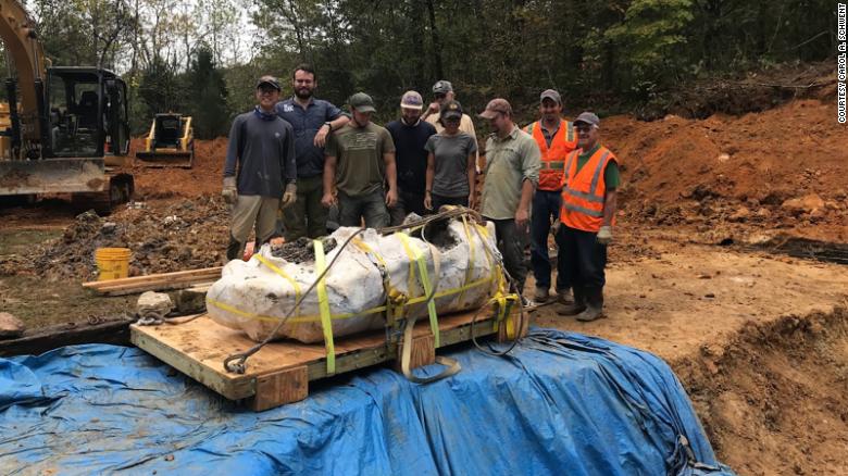 The excavation team is shown with the largest block of the dinosaur -- 2,500 pounds -- removed with the help of a crane October 15.