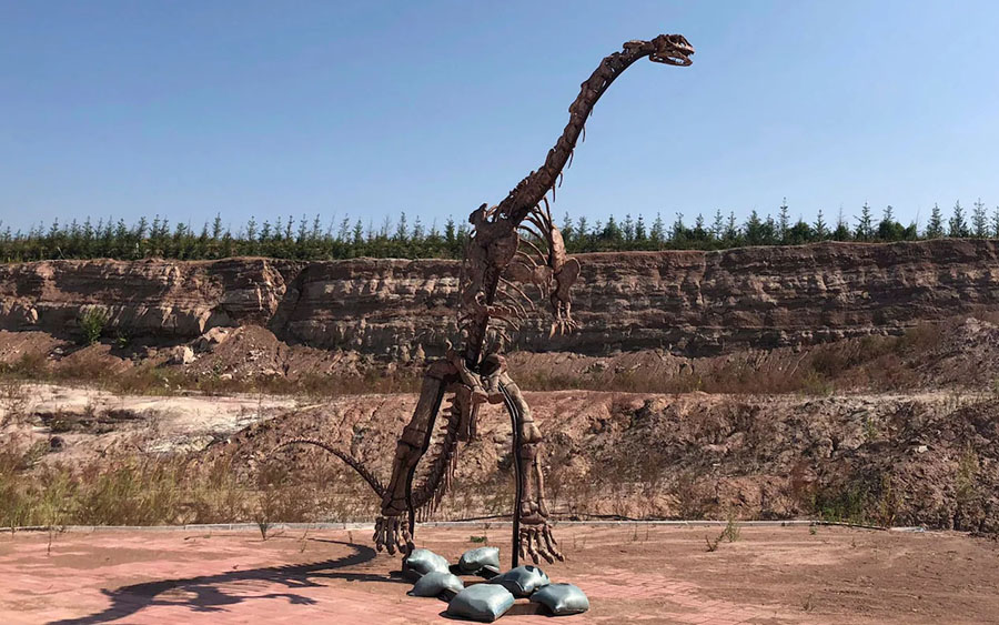 A dinosaur model stands near the site of a future dinosaur museum in Yanji, China CREDIT: AP