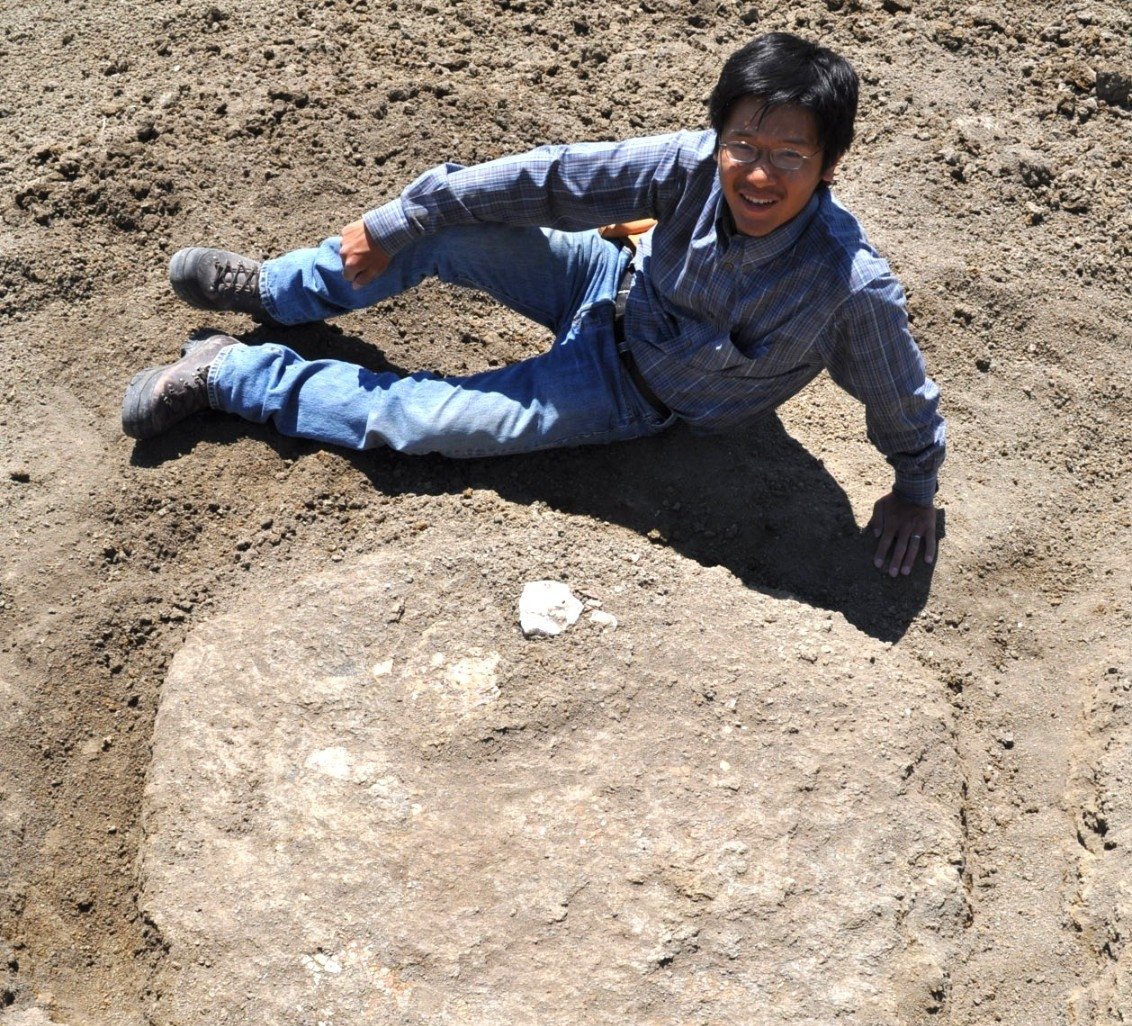 UC paleontologist Takuya Konishi poses with an ammonite fossil he discovered in Alberta, Canada, in 2011. Credit: Darren Tanke/Royal Tyrrell Museum of Paleontology